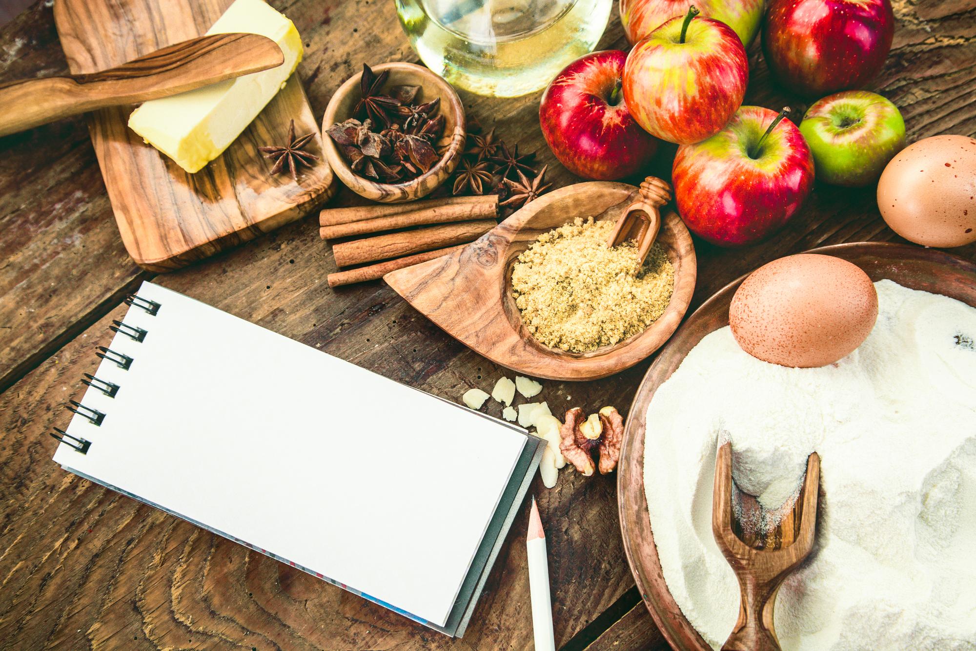 Mesa con ingredientes locales y cuaderno de recetas